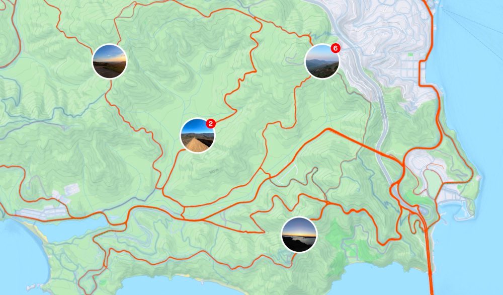 Topographic map overlaid with orange GPS activity tracks and clustered photo pins.