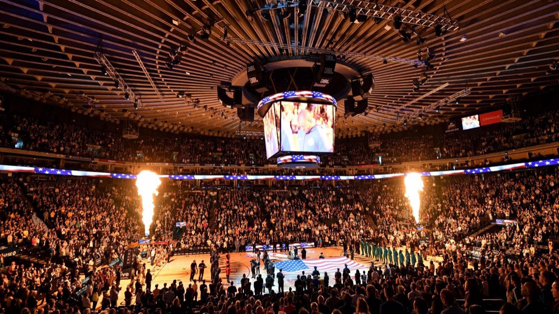 A packed NBA arena during pre-game player introductions.
